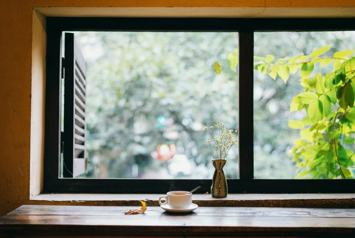 窓辺のコーヒーと小さな花